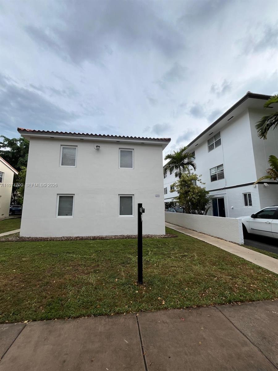A two-story white apartment building stands next to a sidewalk and a grassy lawn — 510 Santander Ave # 1, Coral Gables FL 33134, CORAL GABLES, FL