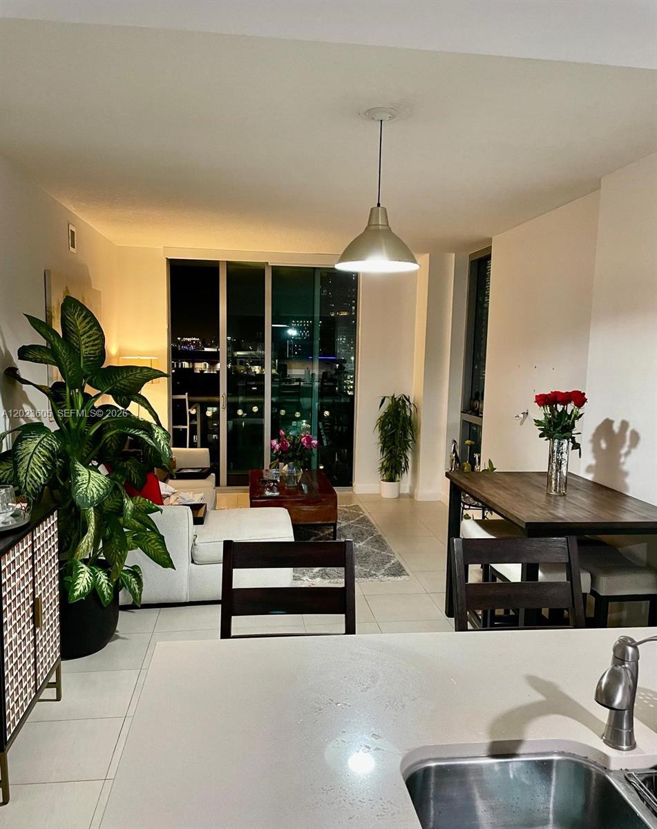 An open-concept living and dining area features a kitchen island, tile floors, and balcony access — 333 NE 24th St # 1108, Miami FL 33137, MIAMI, FL