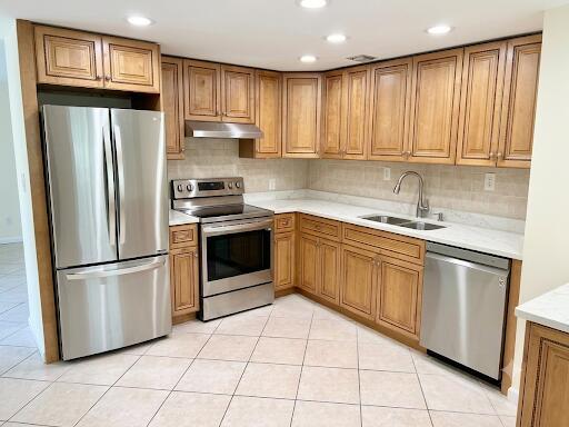 A kitchen features stainless steel appliances, light wood cabinets, and beige tile flooring — 1015 Ainslie A Drive, Boca Raton FL 33434, BOCA RATON, FL