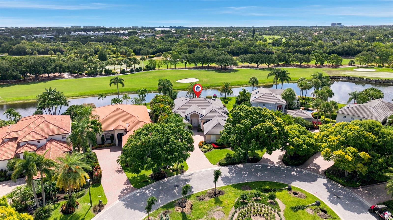 An aerial view shows a residential neighborhood with houses, a golf course, and a lake — 173 N Village Way, Jupiter FL 33458, JUPITER, FL