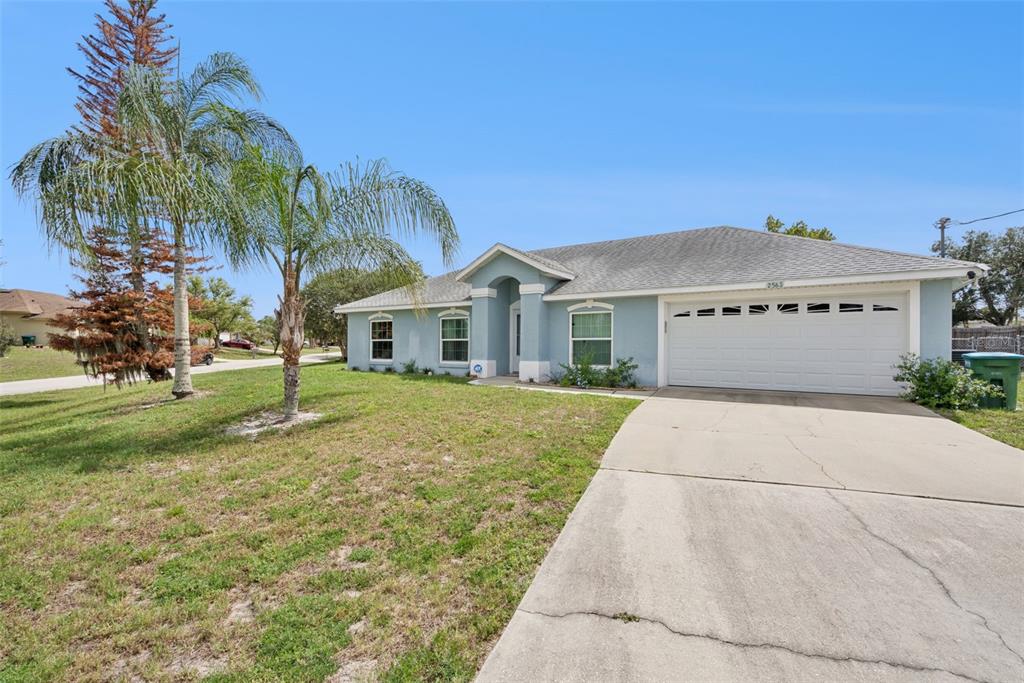A single-story light blue house with a two-car garage and a concrete driveway — 2563 SHEFFIELD DRIVE, DELTONA, FL
