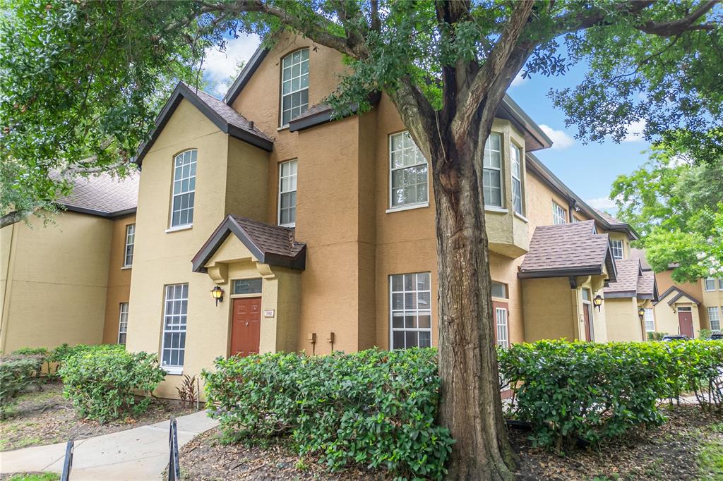 A two-story tan and brown stucco apartment building with a red front door — 6324 RALEIGH STREET UNIT 702, ORLANDO, FL