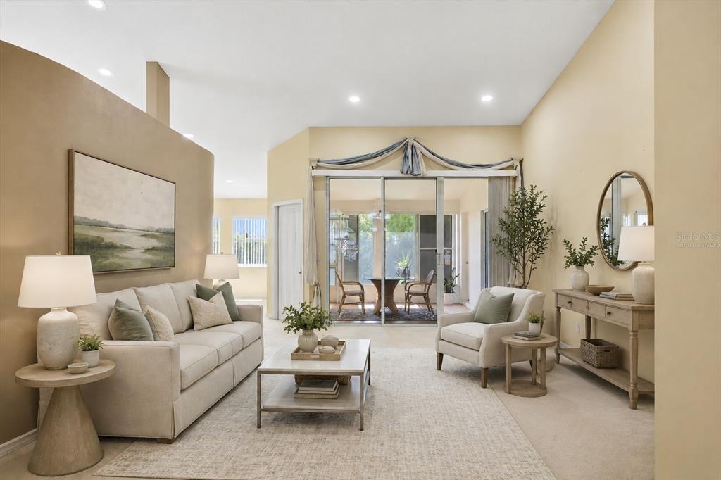 A living room features a beige sofa, two armchairs, a coffee table, and sliding glass doors — 5157 39TH STREET W, BRADENTON, FL