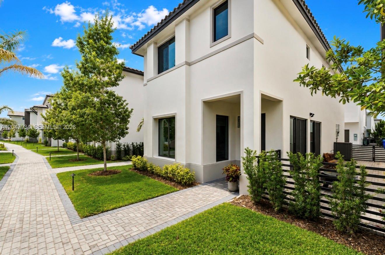 A paved walkway leads past a white building with trees and manicured landscaping — 4388 NW 81st Ave # 4388, Doral FL 33166, DORAL, FL