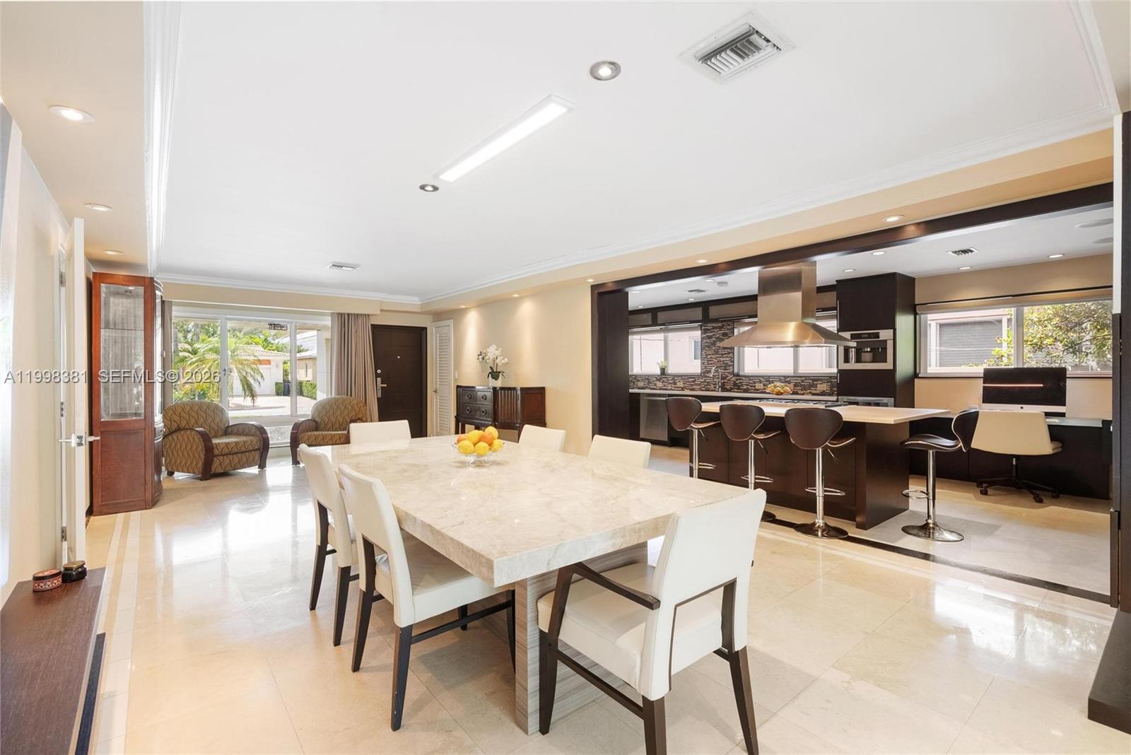 A living room with tile floors, leather furniture, and glass doors opening to a pool — 9141 Abbott Ave, Surfside FL 33154, SURFSIDE, FL