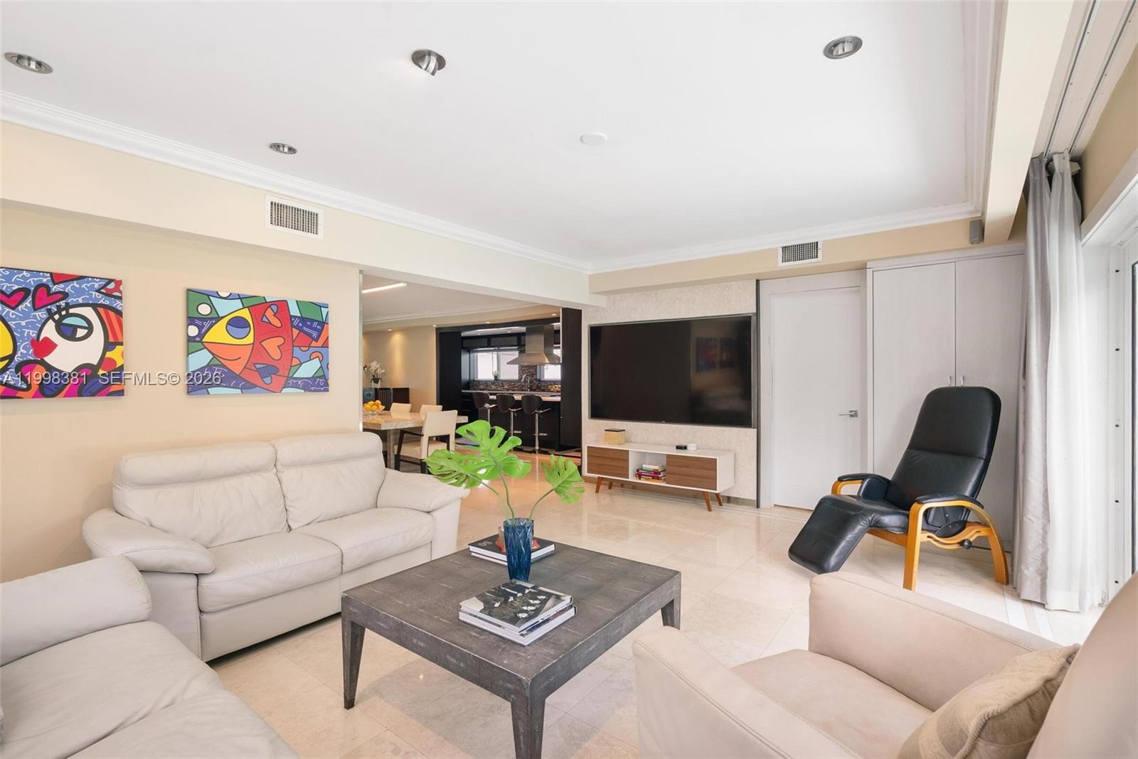 A dining room with a stone table, white chairs, and an adjacent kitchen with barstools — 9141 Abbott Ave, Surfside FL 33154, SURFSIDE, FL