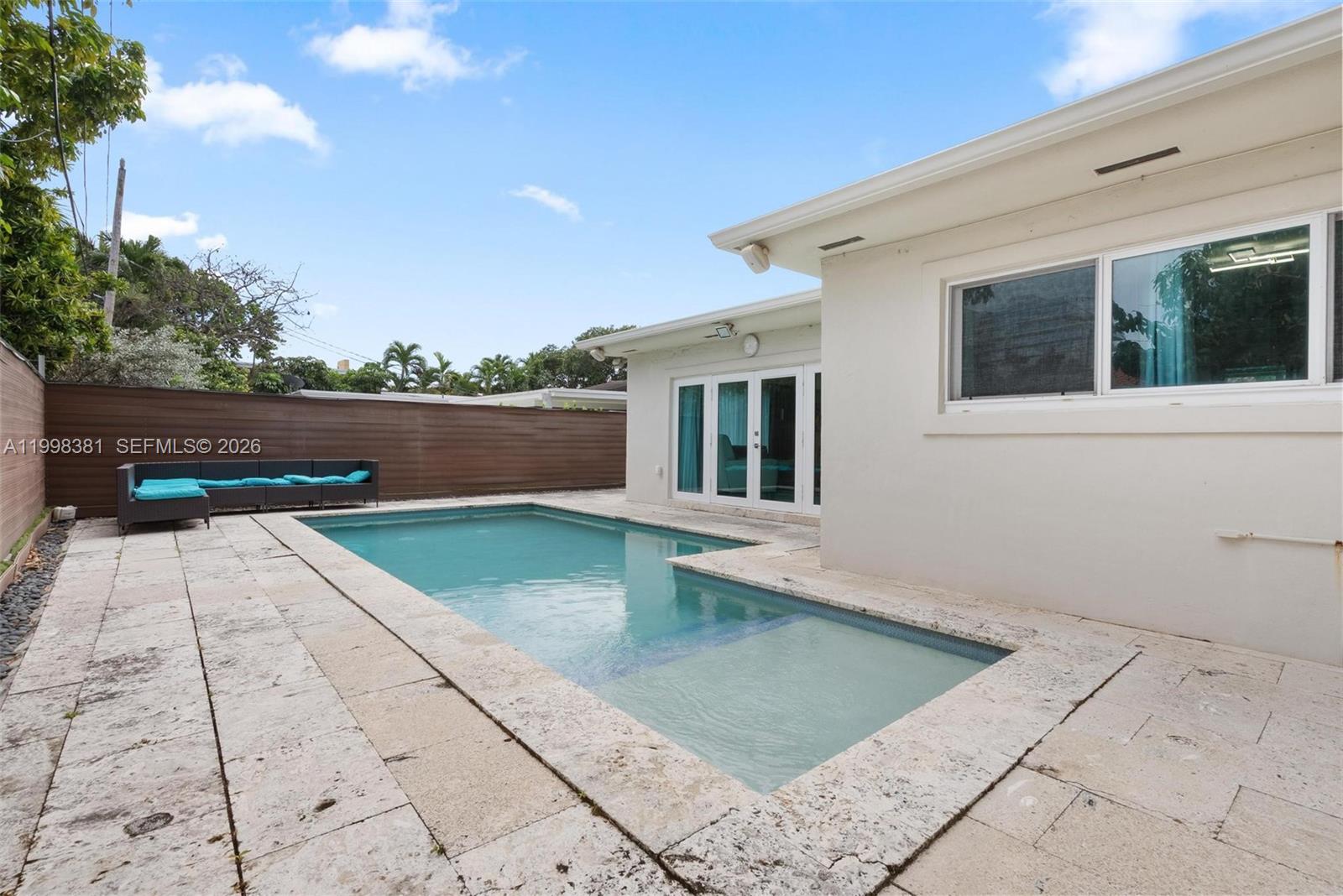 A living room features a white sofa, a black recliner, and a central coffee table — 9141 Abbott Ave, Surfside FL 33154, SURFSIDE, FL