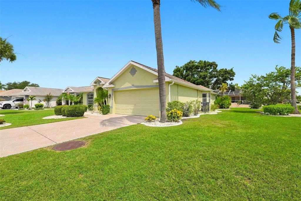 A light green single-story house with a two-car garage and a paved driveway — 2242 W DEL WEBB BOULEVARD, SUN CITY CENTER, FL