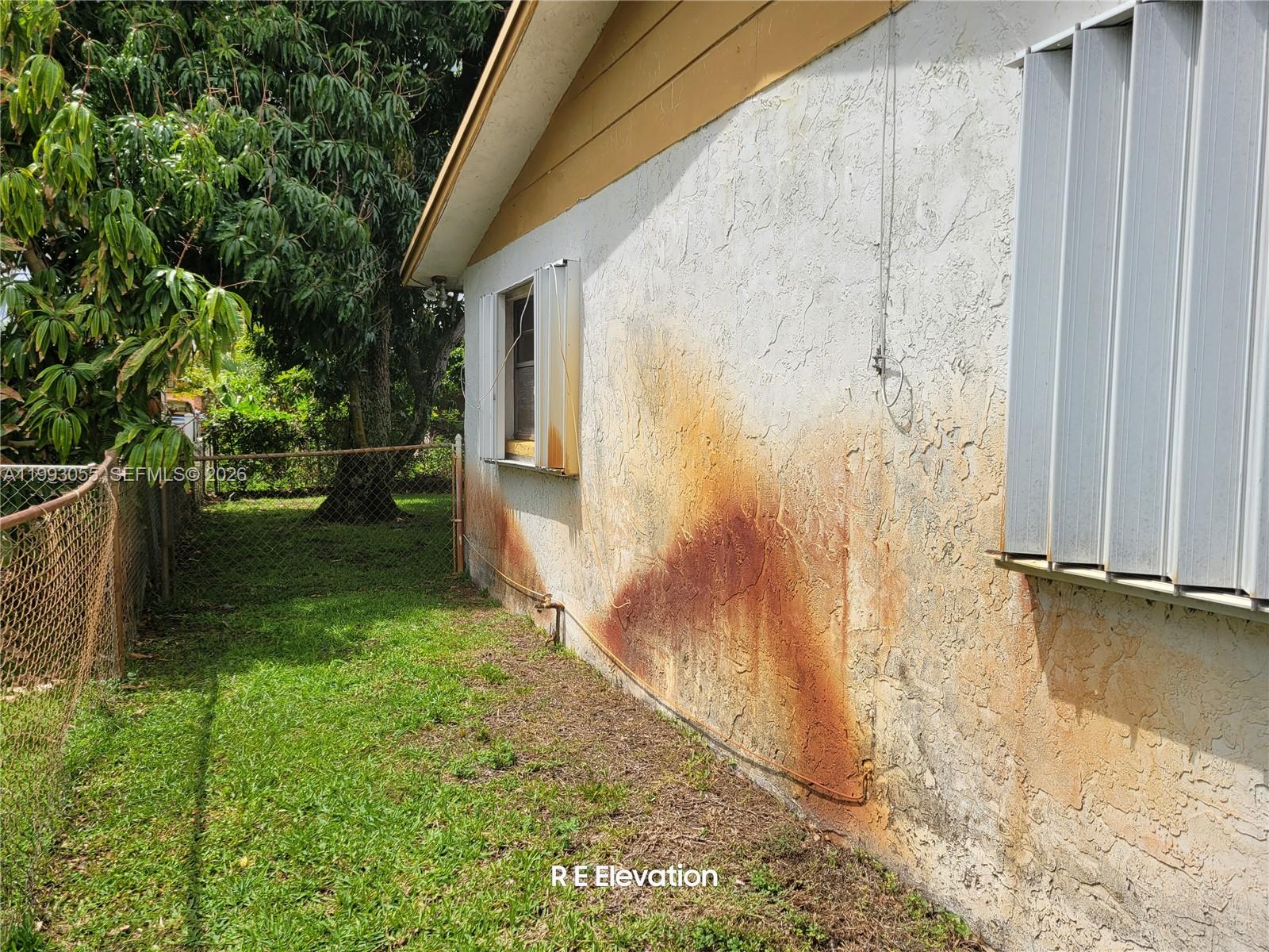 The exterior wall of a house shows significant rust-colored staining near the ground — 1149 NW 45th Ave, Lauderhill FL 33313, LAUDERHILL, FL