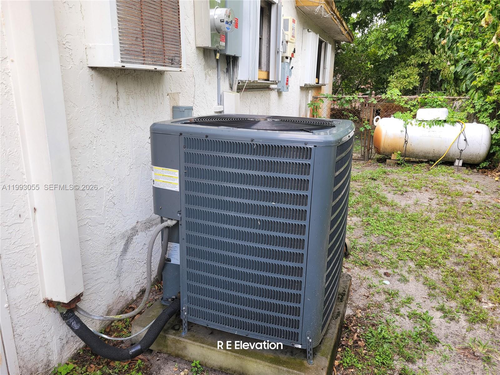 An outdoor air conditioning unit sits on a concrete pad next to a house — 1149 NW 45th Ave, Lauderhill FL 33313, LAUDERHILL, FL