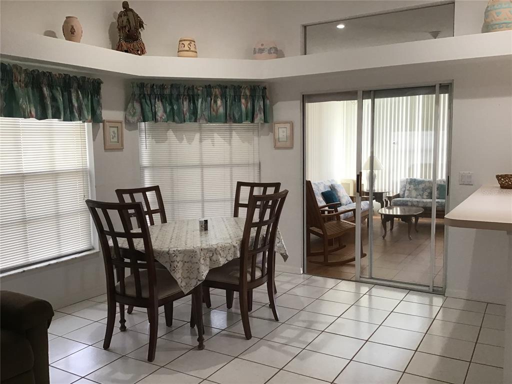 A dining area with tile floors, a table for four, and sliding glass doors — 2984 TUSKET AVENUE, NORTH PORT, FL