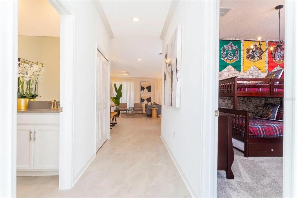 A hallway leads to a living area, flanked by a bathroom and a themed bedroom — 2994 PROTAGONIST STREET, KISSIMMEE, FL