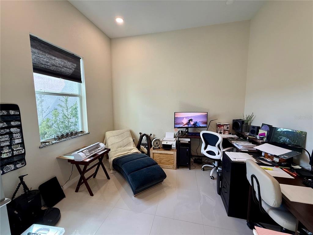 A home office features a desk, computer, lounge chair, and a window with blinds — 3312 16TH STREET W, LEHIGH ACRES, FL