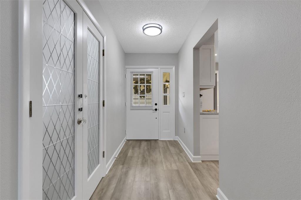 A beige house exterior features a front door with a wreath and a welcome mat — 4418 LA JOLLA DRIVE, BRADENTON, FL