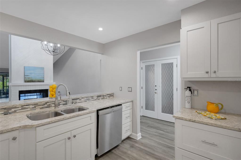 A bright entryway features light wood-look flooring, gray walls, and a white front door — 4418 LA JOLLA DRIVE, BRADENTON, FL