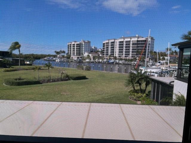 A view of a marina and apartment buildings seen through a screened-in porch — 3250 SOUTHSHORE DRIVE UNIT 54-B, PUNTA GORDA, FL