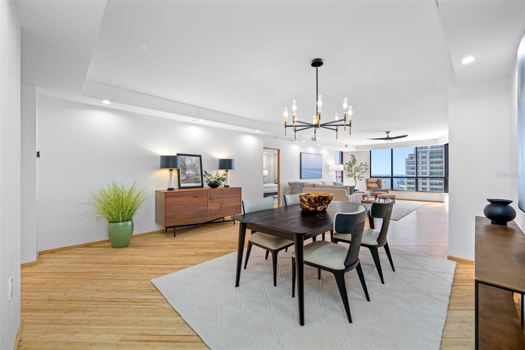 A dining area with a dark wood table, modern chandelier, and light wood flooring — 1 BEACH DRIVE SE UNIT 2211, ST PETERSBURG, FL