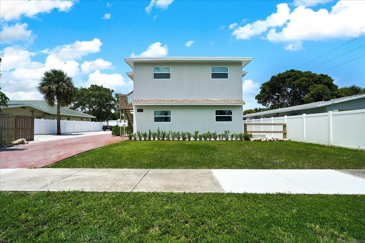 A two-story, light gray house with a front lawn and a red paved driveway — 305 Cypress Drive E # 5, Lake Park FL 33403, LAKE PARK, FL