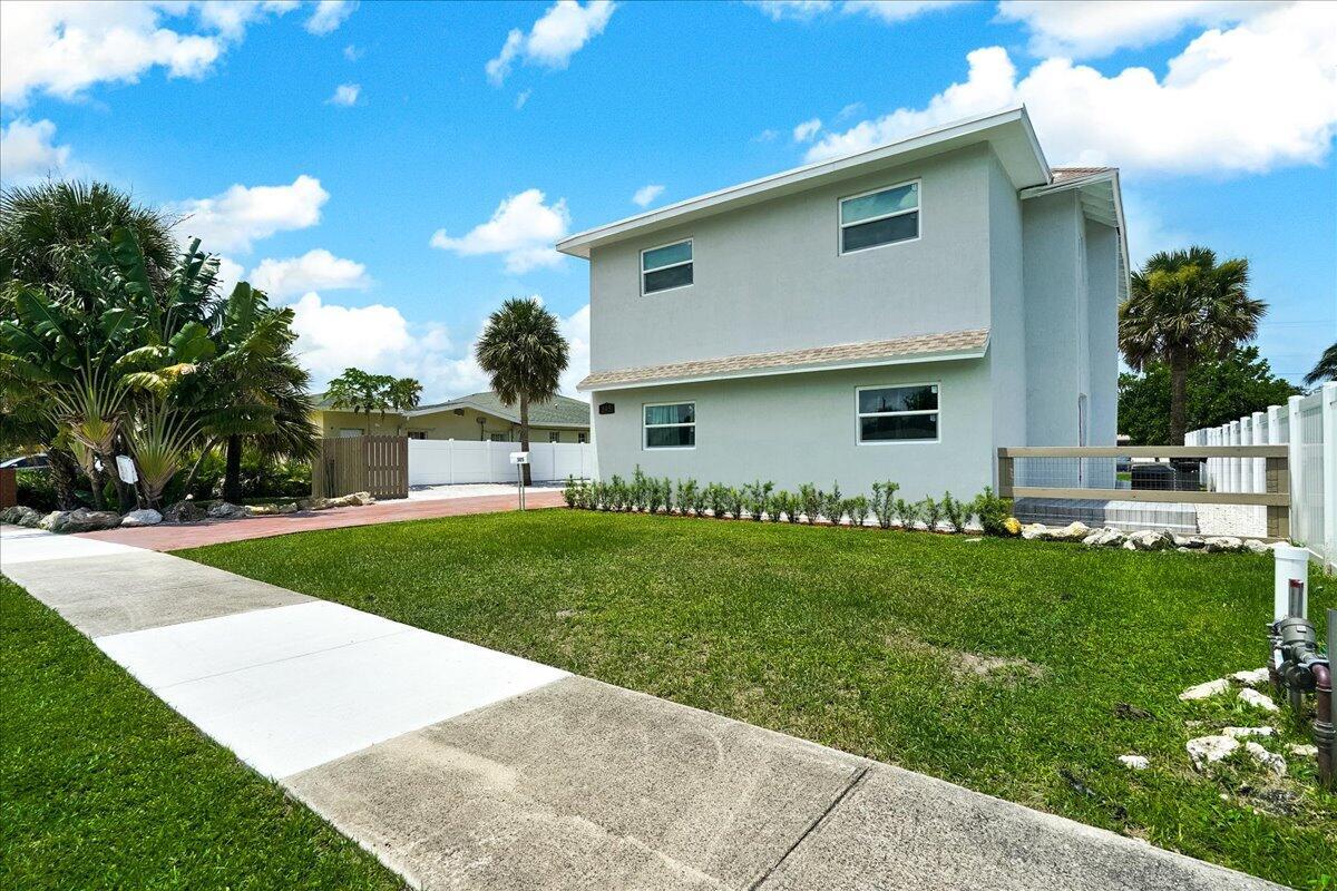 A two-story light gray house with a front lawn and a paved driveway — 305 Cypress Drive E # 5, Lake Park FL 33403, LAKE PARK, FL