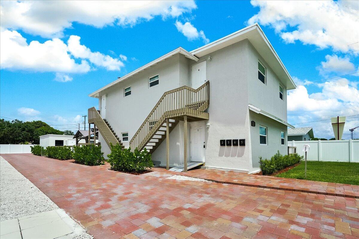 A two-story apartment building with a wooden staircase and a brick-paved driveway — 305 Cypress Drive E # 5, Lake Park FL 33403, LAKE PARK, FL