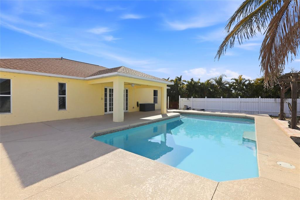 A yellow house with a covered patio and a swimming pool in the backyard — 1209 NW 19TH STREET, CAPE CORAL, FL