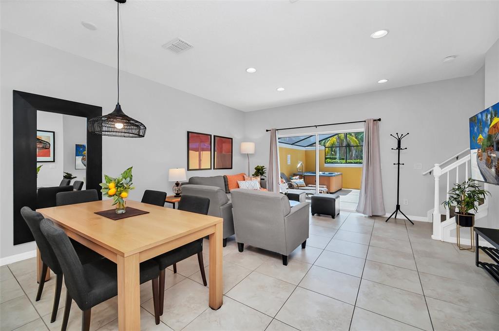 A dining area and living room with tile floors open to a patio with a hot tub — 3070 YELLOW LANTANA LANE, KISSIMMEE, FL