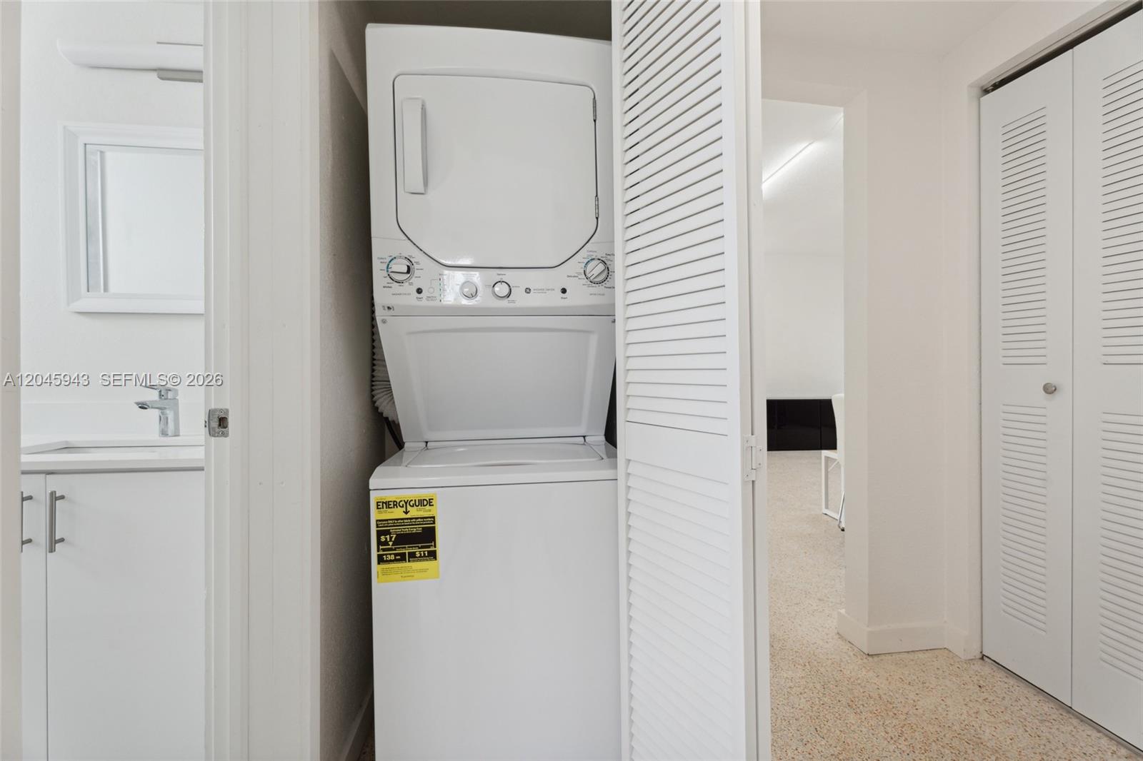 A stacked washer and dryer unit is located in a small closet near a bathroom — 835 80th St # 3, Miami Beach FL 33141, MIAMI BEACH, FL