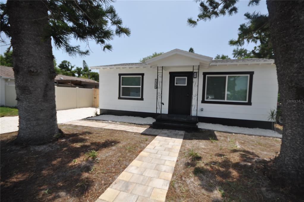 A white single-story house with black trim and a paved walkway leading to the entrance — 1319 S 56TH STREET, GULFPORT, FL