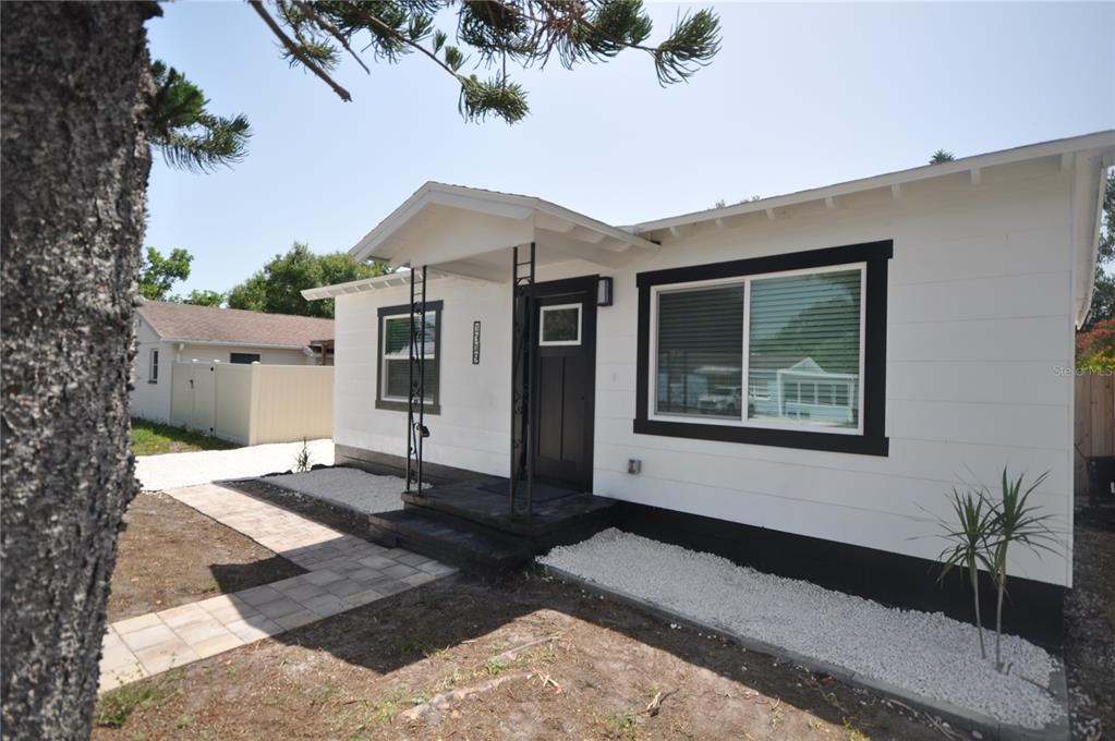 A white house with black trim features a front porch and a paved walkway — 1319 S 56TH STREET, GULFPORT, FL