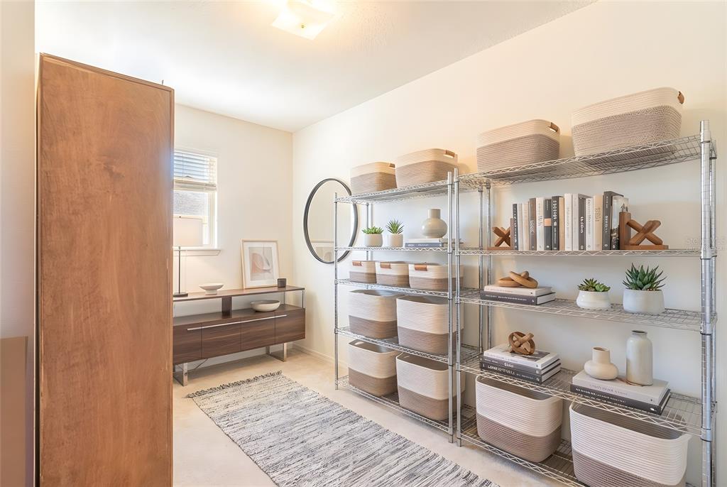 A room features a metal shelving unit with storage baskets, a wooden cabinet, and a rug — 4317 DINNER LAKE DRIVE, LAKE WALES, FL