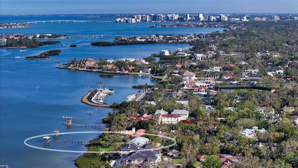 An aerial view of a coastal property featuring a private dock and waterfront home — 1440 KIMLIRA LANE, SARASOTA, FL
