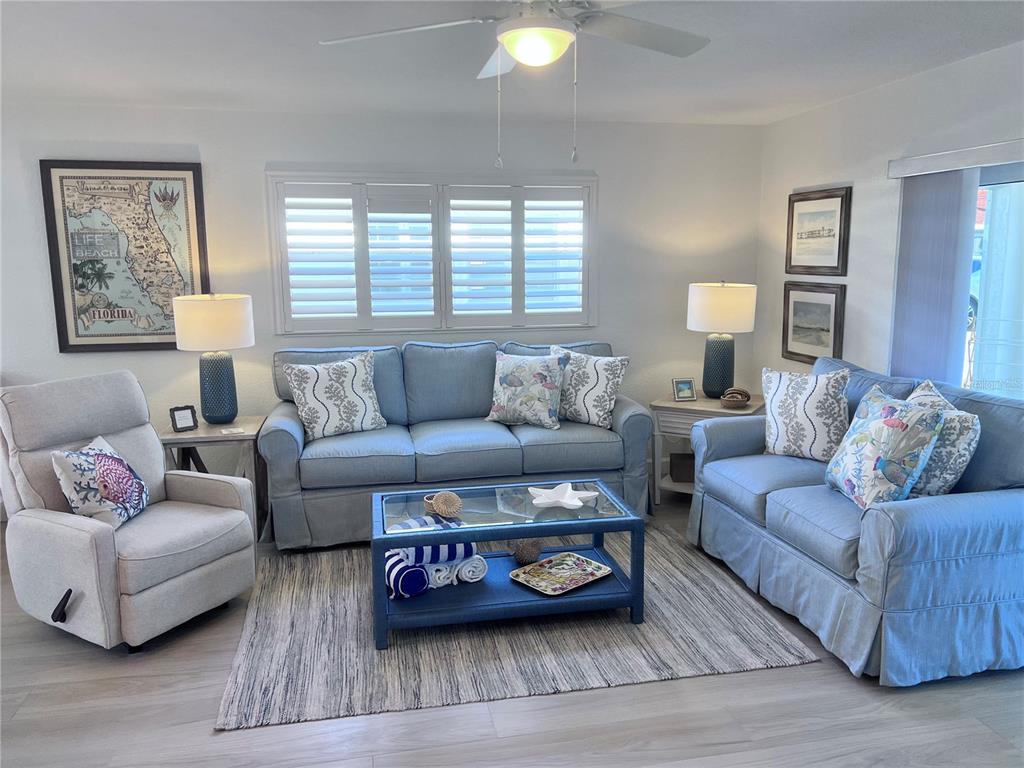 A living room features a blue sofa and loveseat, a recliner, and a coffee table — 6154 MIDNIGHT PASS ROAD UNIT A11, SARASOTA, FL