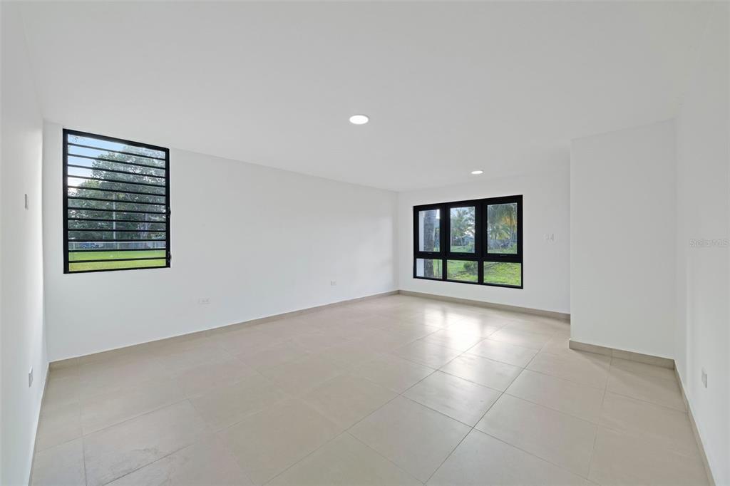 An empty room with white walls, large windows, and light-colored tile flooring — RAMON MARIN ST. LEVITTOWN LAKES UNIT EA-34, TOA BAJA, PR