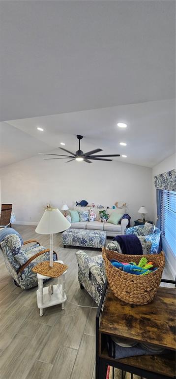 A living room features a vaulted ceiling, a large ceiling fan, and coastal-themed furniture — 2408 MONTPELIER ROAD, PUNTA GORDA, FL