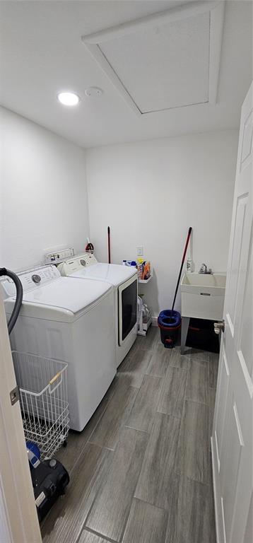 A laundry room featuring a washer, dryer, utility sink, and gray wood-look tile flooring — 2408 MONTPELIER ROAD, PUNTA GORDA, FL