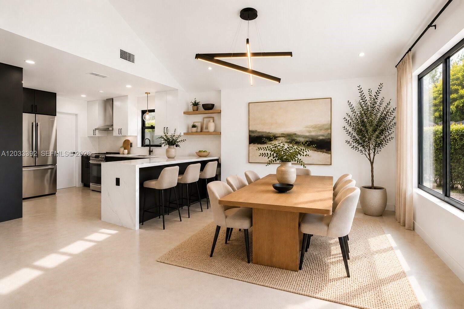 A dining area with a wooden table and chairs sits adjacent to a modern kitchen — 1543 SW 1st Ave, Boca Raton FL 33432, BOCA RATON, FL