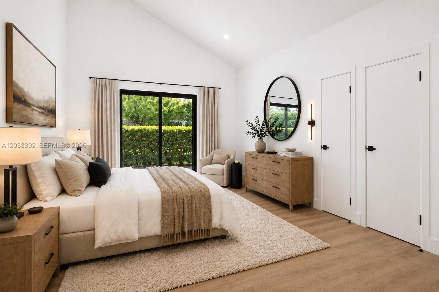 This bedroom features a vaulted ceiling, sliding glass doors, and light wood flooring — 1543 SW 1st Ave, Boca Raton FL 33432, BOCA RATON, FL