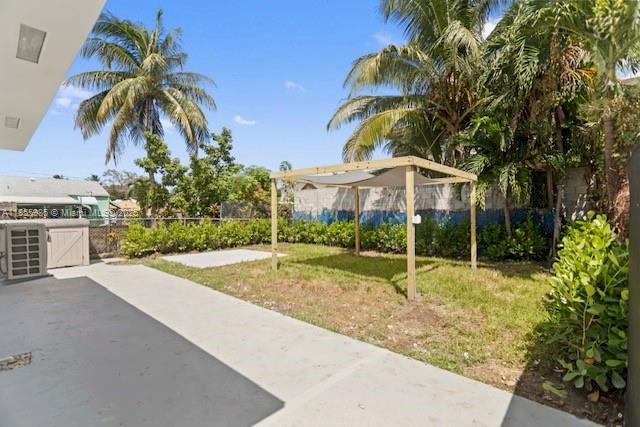 A backyard features a concrete patio, a small grassy lawn, and a wooden shade structure — 3125 NW 21st Ct # 01, Miami FL 33142, MIAMI, FL