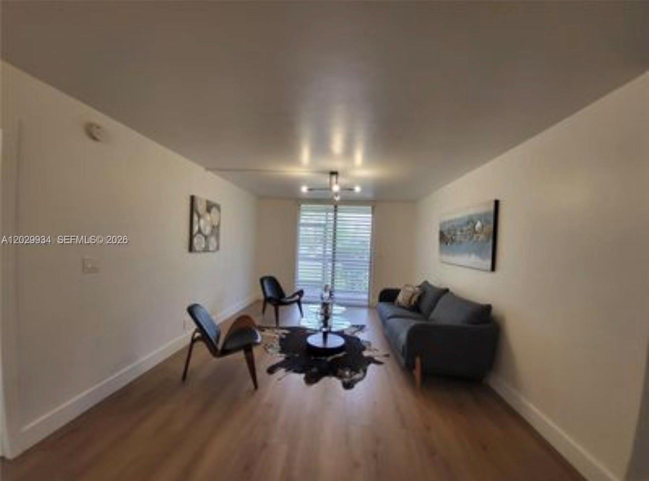 A living room features light wood flooring, a grey sofa, two chairs, and a coffee table — 733 SE 1st Way # 109, Deerfield Beach FL 33441, DEERFIELD BEACH, FL