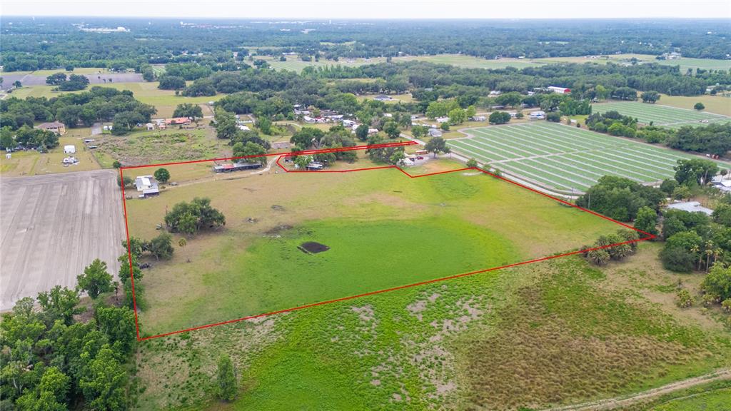 An aerial view shows a large, grassy rural property outlined in red with several structures — 1616 MCGEE ROAD, PLANT CITY, FL