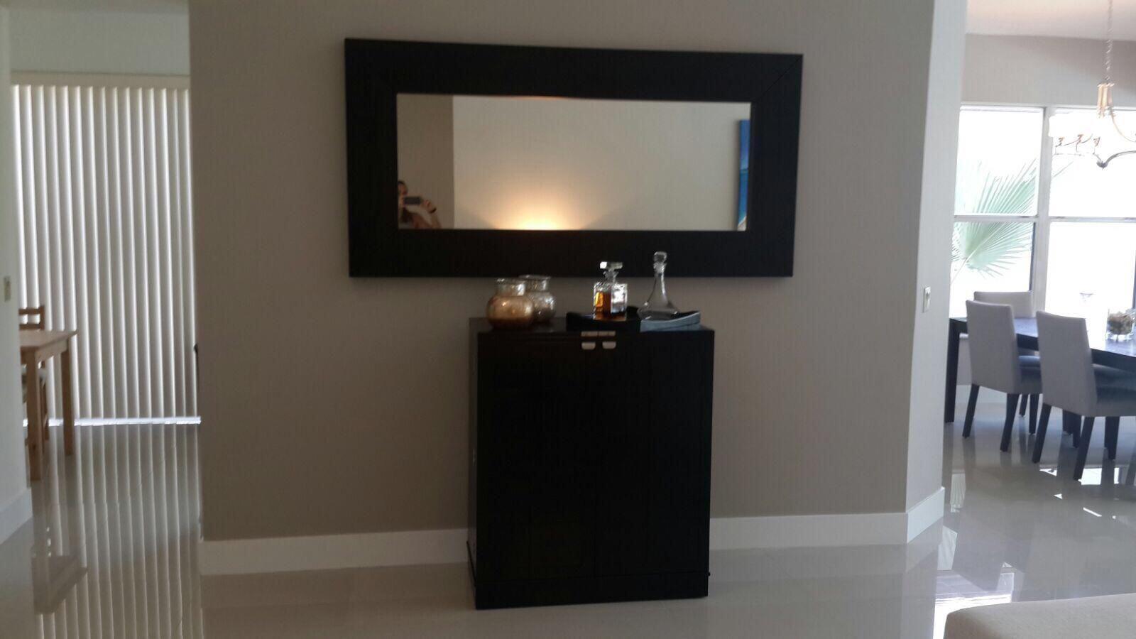 A dark wood cabinet sits against a beige wall beneath a large rectangular mirror — 5463 NW 20th Avenue, Boca Raton FL 33496, BOCA RATON, FL