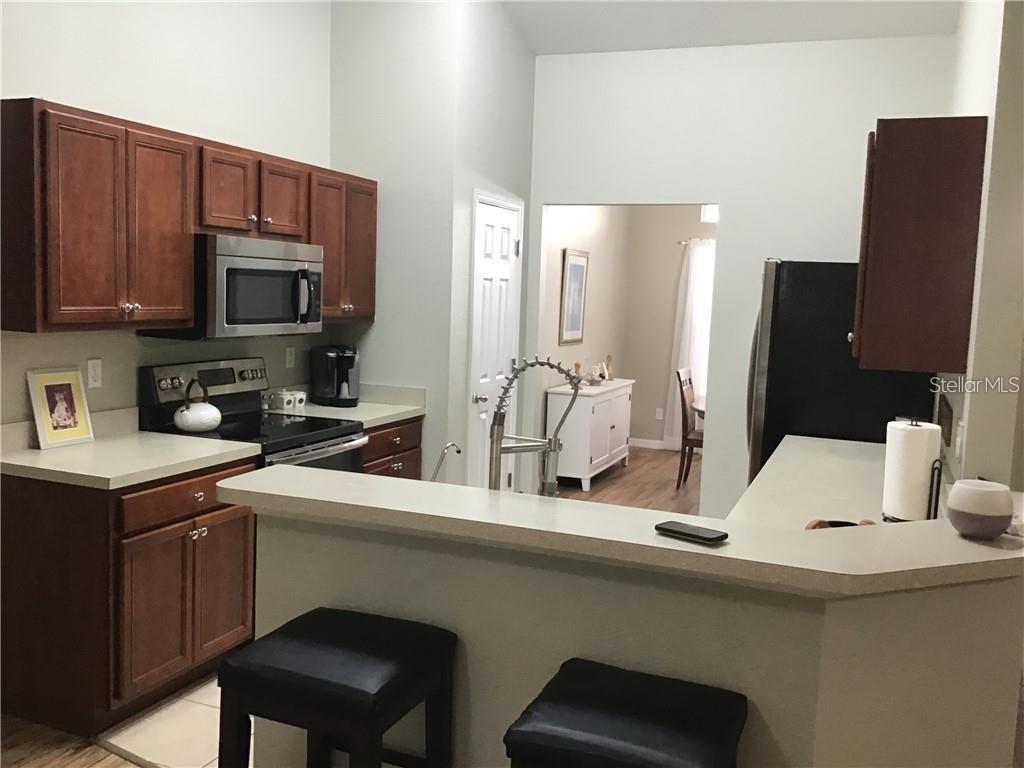 A kitchen features dark wood cabinets, stainless steel appliances, and a breakfast bar — 2091 SNOWFLAKE LANE, NORTH PORT, FL