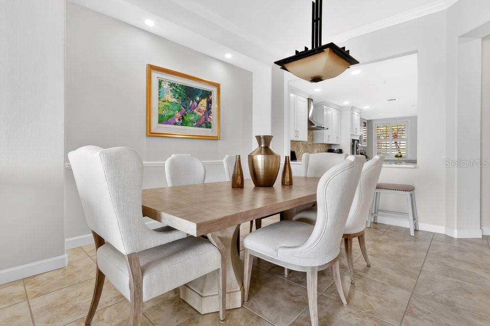 A bright living room features a white leather sectional, glass coffee table, and balcony access — 8755 THE ESPLANADE UNIT 104, ORLANDO, FL