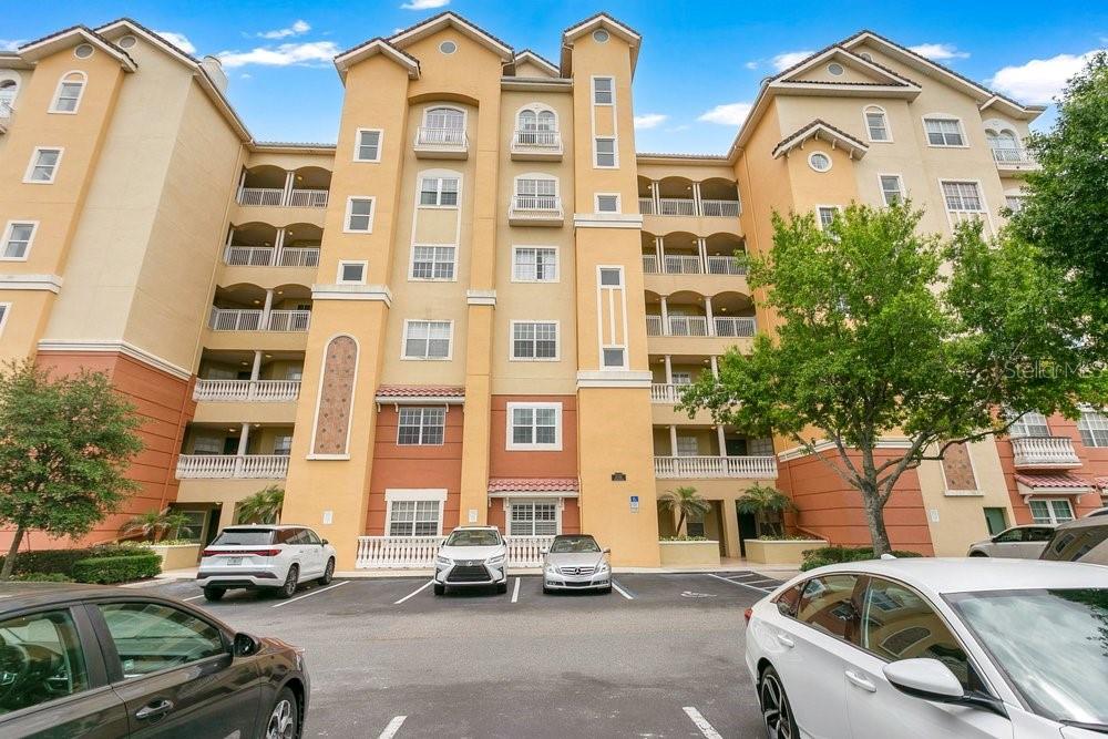 A living room with tile floors, a white sofa, a television, and a balcony view — 8755 THE ESPLANADE UNIT 104, ORLANDO, FL