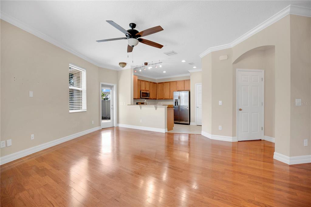An open-concept living area with hardwood floors, a ceiling fan, and an adjacent kitchen — 2403 S SHINE AVENUE UNIT B, ORLANDO, FL