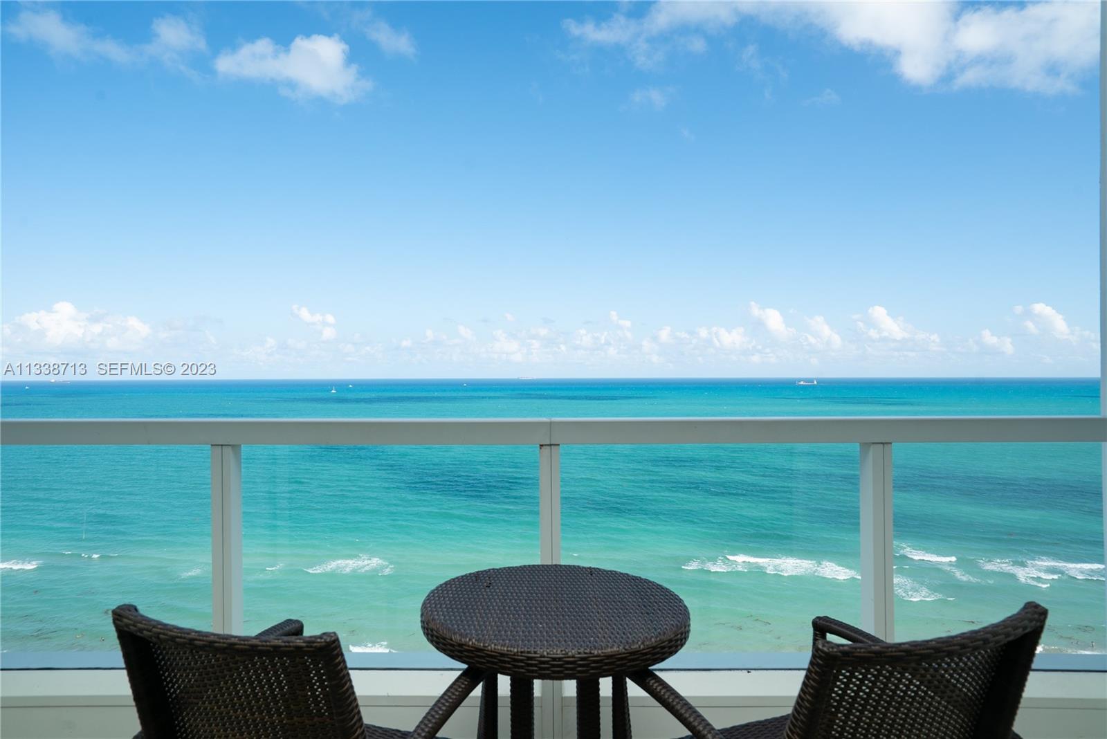 A balcony with two chairs and a small table overlooks the ocean — 4391 Collins Ave, Miami Beach FL 33140, MIAMI BEACH, FL