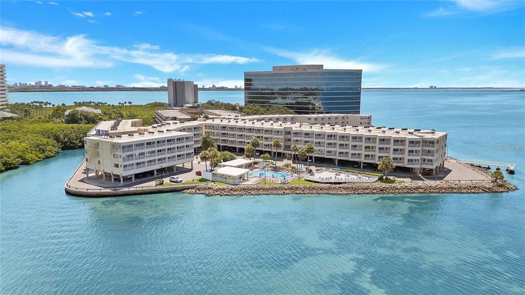 An aerial view of a multi-story waterfront apartment complex with a pool and parking area — 2506 N ROCKY POINT DRIVE UNIT 331 and #275, TAMPA, FL
