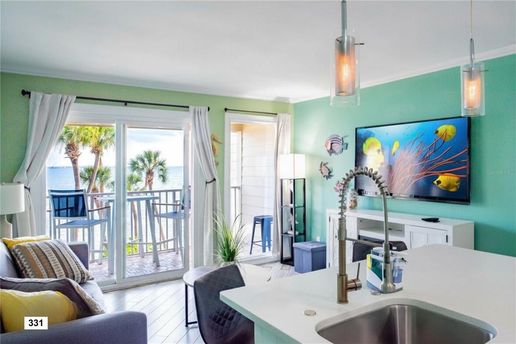 A living room and kitchen area with a view of the ocean through sliding doors — 2506 N ROCKY POINT DRIVE UNIT 331 and #275, TAMPA, FL