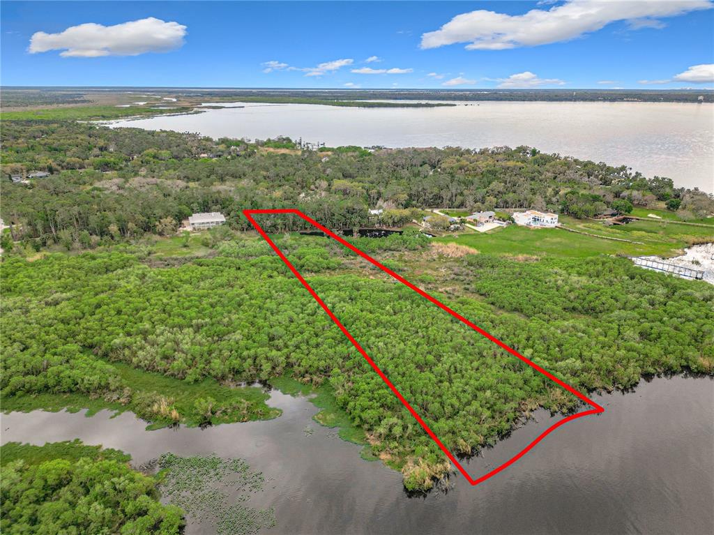 An aerial view shows a rectangular plot of land outlined in red near a lake — 1364 SIOUX TRAIL, DELTONA, FL