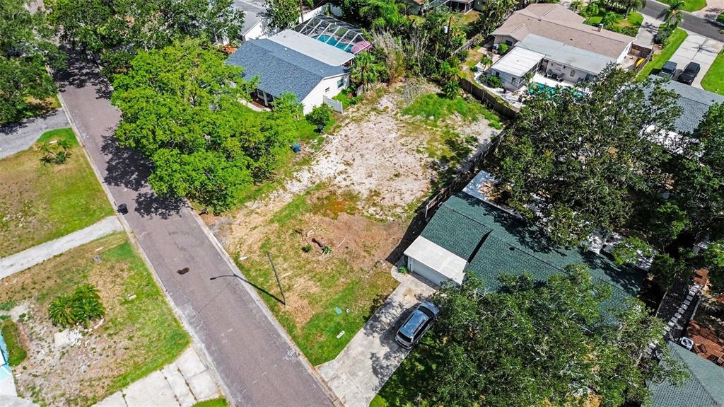 An aerial view shows a vacant residential lot situated between two houses on a street — 1737 COLORADO AVENUE NE, ST PETERSBURG, FL